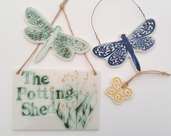 Ceramic dragonflies and a potting shed sign